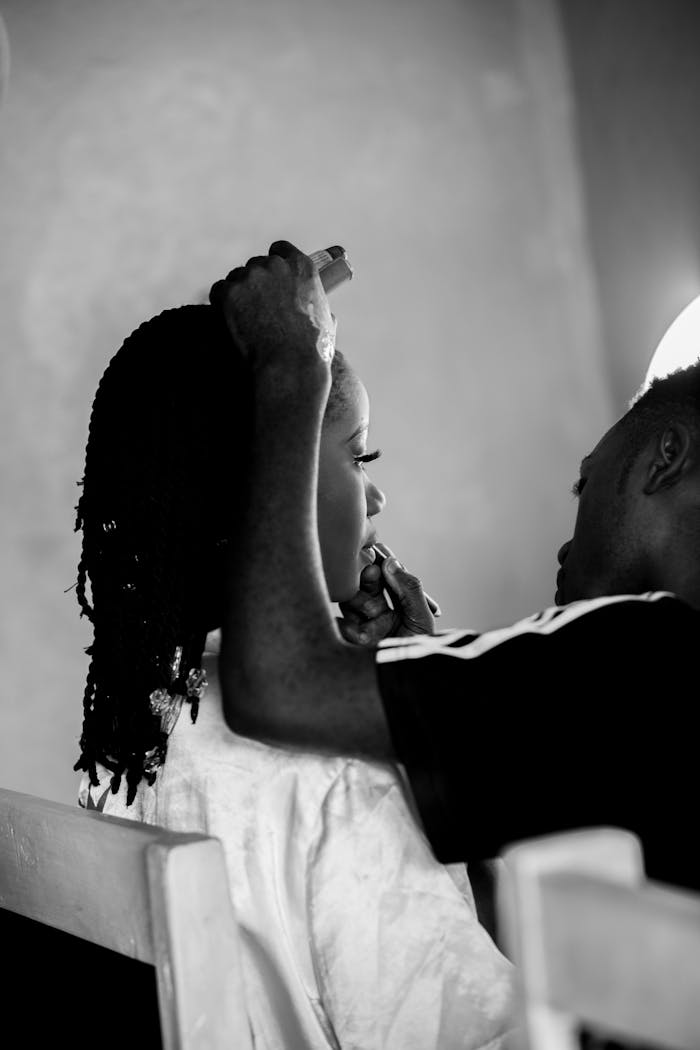Home A makeup artist applying cosmetics to a client's face in a serene setting.