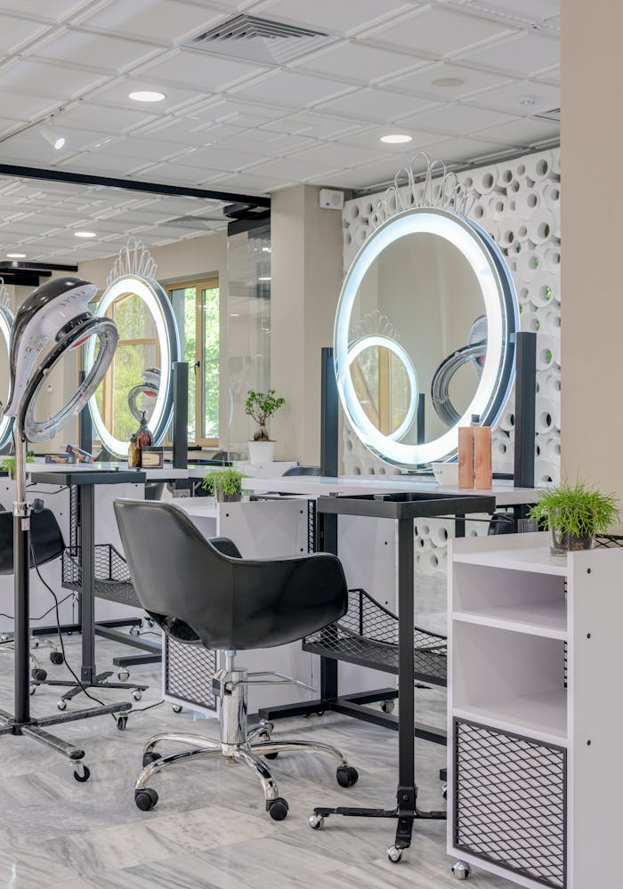 Services Elegant hair salon interior featuring sleek design and illuminated mirrors for a stylish beauty experience.